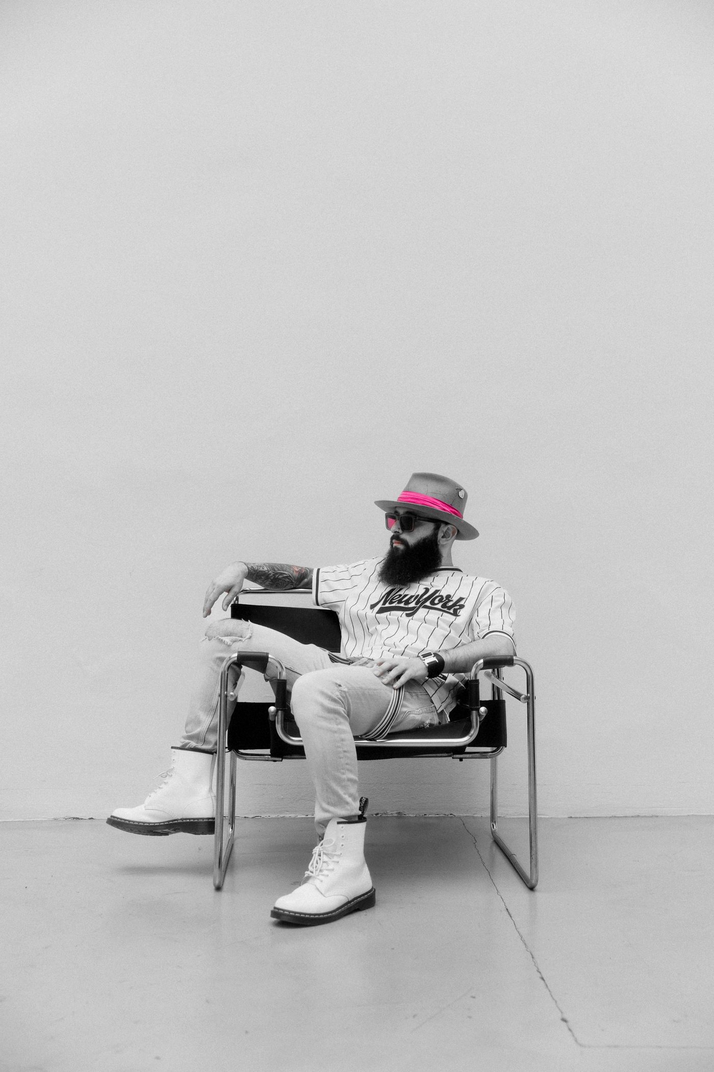 Prince Moe in a pink-banded hat and sunglasses, seated in a chrome armchair